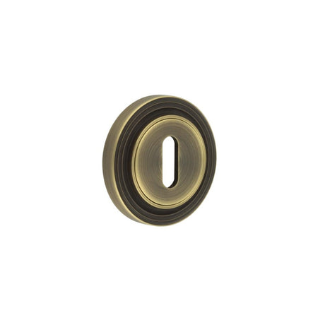 This is an image showing the Frelan - Burlington Standard Keyway Escutcheons Reeded Rose Antique Brass available to order from Trade Door Handles in Kendal