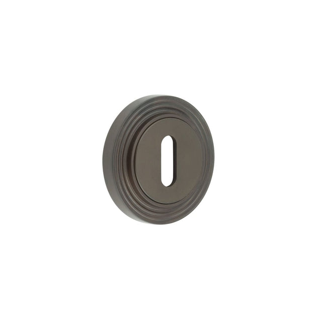 This is an image showing the Frelan - Burlington Standard Keyway Escutcheons Reeded Rose Dark Bronze available to order from Trade Door Handles in Kendal