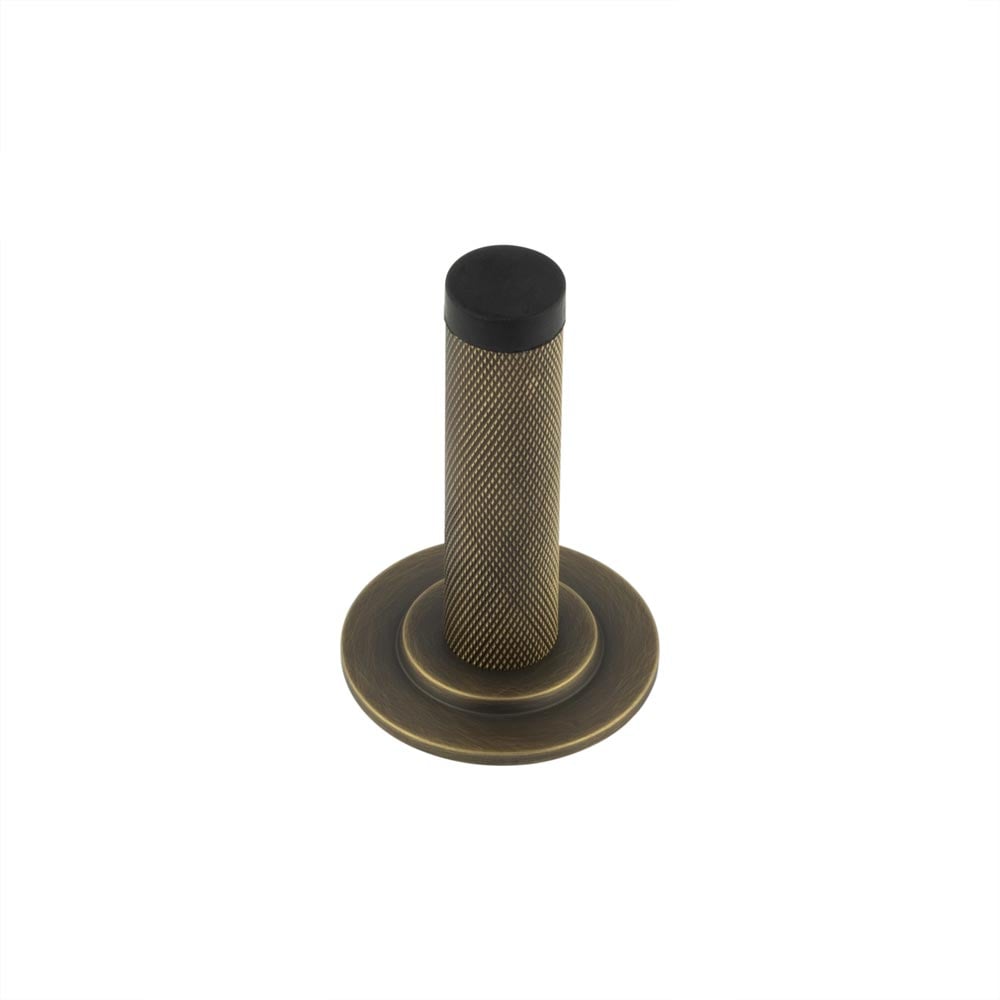 This is an image showing the Frelan - Burlington Knurled Wall Mounted Doorstops Stepped Rose Antique Brass available to order from Trade Door Handles in Kendal