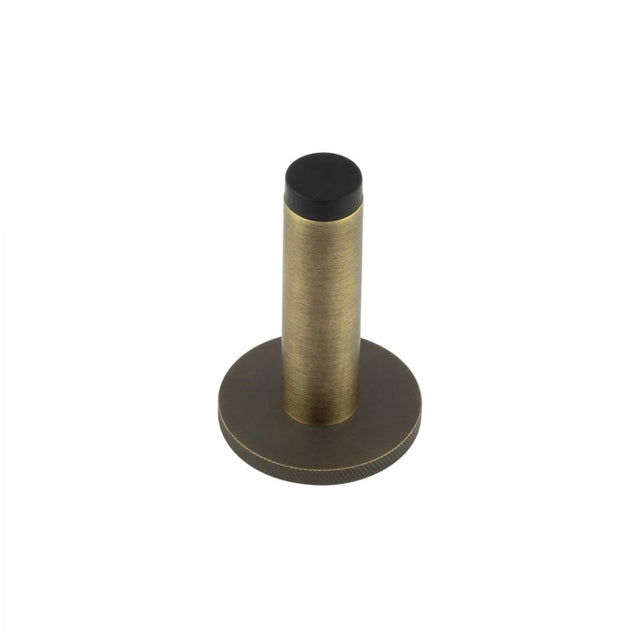 This is an image showing the Frelan - Burlington Plain Wall Mounted Door Stops Knurled Rose Antique Brass available to order from Trade Door Handles in Kendal