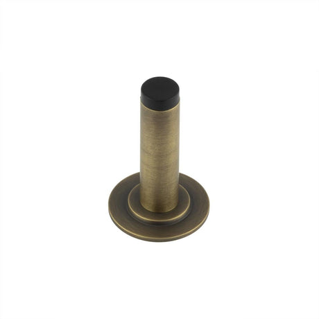 This is an image showing the Frelan - Burlington Plain Wall Mounted Door Stops Stepped Rose Antique Brass available to order from Trade Door Handles in Kendal