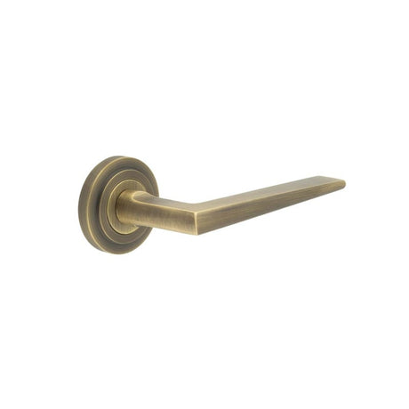 This is an image showing the Frelan - Mayfair Door Handle on Stepped Rose Antique Brass available to order from Trade Door Handles in Kendal