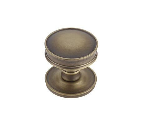 This is an image showing the Burlington - Berkeley cupboard knob - Antique Brass available to order from Trade Door Handles in Kendal