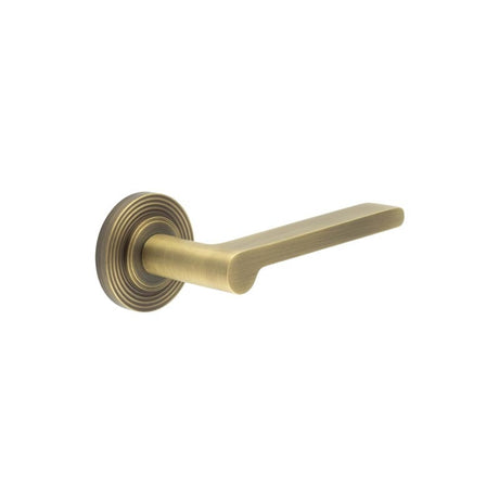 This is an image showing the Frelan - Fitzrovia Door Handles Reeded Rose Antique Brass available to order from Trade Door Handles in Kendal