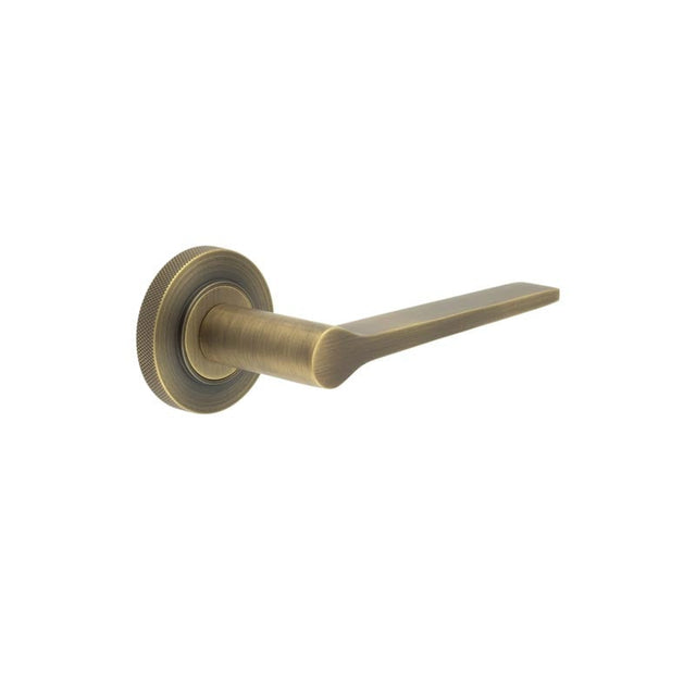 This is an image showing the Frelan - Knightsbridge Door Handle on Knurled Rose Antique Brass available to order from Trade Door Handles in Kendal