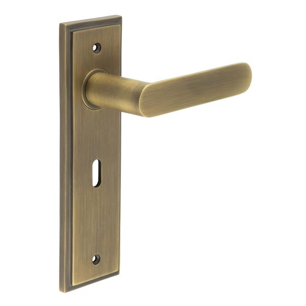 This is an image showing the Frelan - Kensington Door Handle Lock Backplate Antique Brass available to order from Trade Door Handles in Kendal