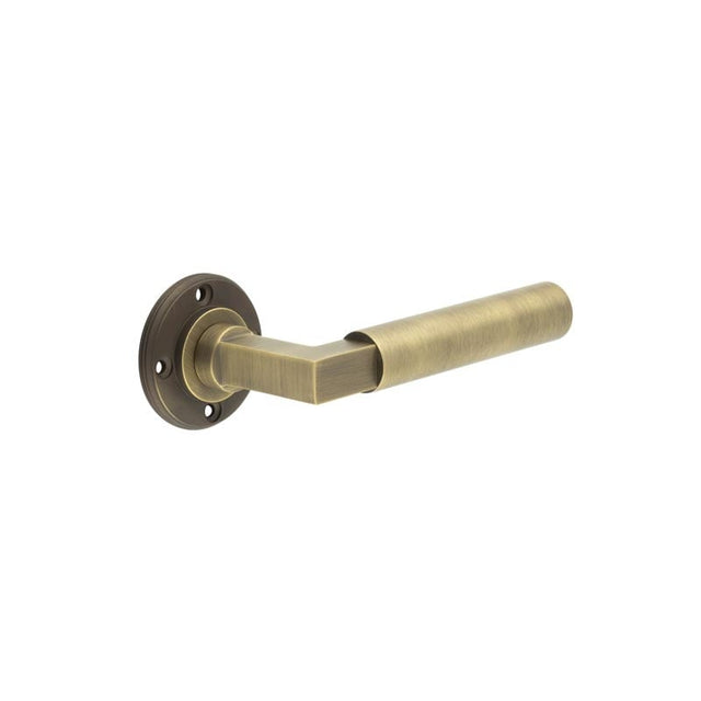 This is an image showing the Burlington - Westminster lever on rose - Antique Brass available to order from Trade Door Handles in Kendal