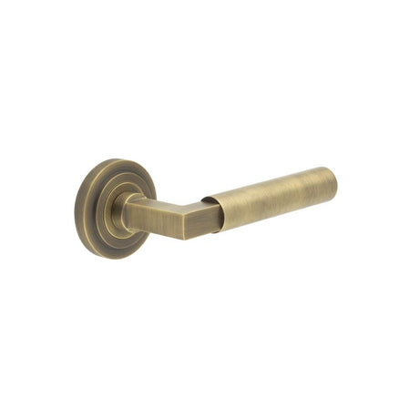 This is an image showing the Frelan - Westminster Door Handle on Stepped Rose Antique Brass available to order from Trade Door Handles in Kendal