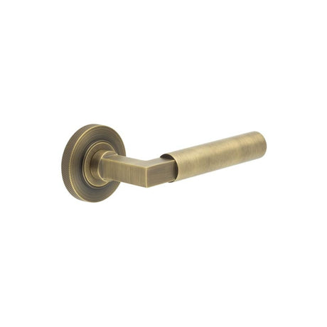 This is an image showing the Frelan - Westminster Door Handle on Knurled Rose Antique Brass available to order from Trade Door Handles in Kendal