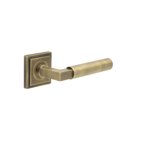 This is an image showing the Frelan - Westminster Door Handle on Square Stepped Rose Antique Brass available to order from Trade Door Handles in Kendal