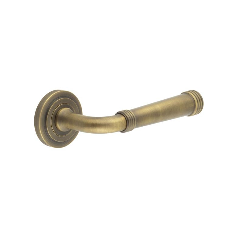 This is an image showing the Frelan - Highgate Door Handles Stepped Rose Antique Brass available to order from Trade Door Handles in Kendal