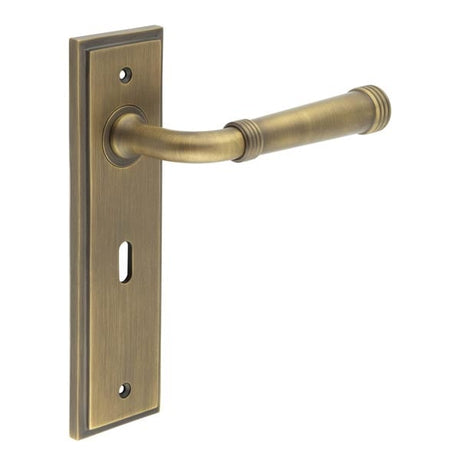 This is an image showing the Frelan - Highgate Door Handle Lock Backplate Antique Brass available to order from Trade Door Handles in Kendal