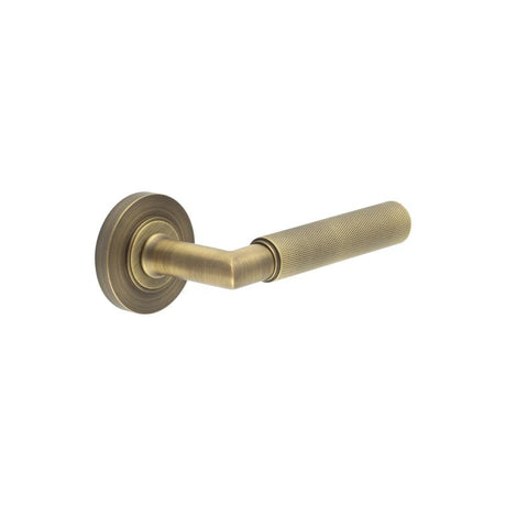 This is an image showing the Frelan - Piccadilly Door Handle on Plain Rose Antique Brass available to order from Trade Door Handles in Kendal