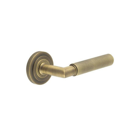 This is an image showing the Frelan - Piccadilly Door Handle on Stepped Rose Antique Brass available to order from Trade Door Handles in Kendal