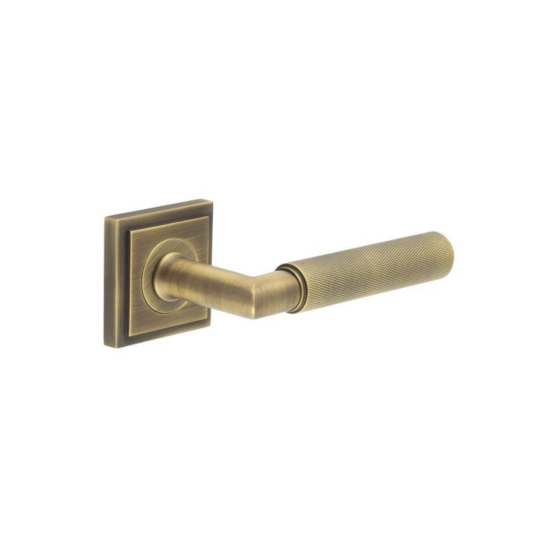 This is an image showing the Frelan - Piccadilly Door Handle on Stepped Square Rose Antique Brass available to order from Trade Door Handles in Kendal