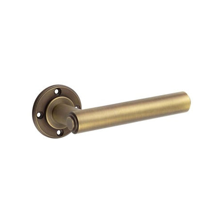 This is an image showing the Burlington - Richmond Antique Brass Lever on Rose Door Handle - Roses Sold Separ available to order from Trade Door Handles in Kendal