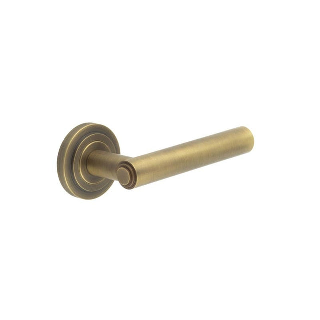 This is an image showing the Frelan - Richmond Door Handles Stepped Rose Antique Brass available to order from Trade Door Handles in Kendal