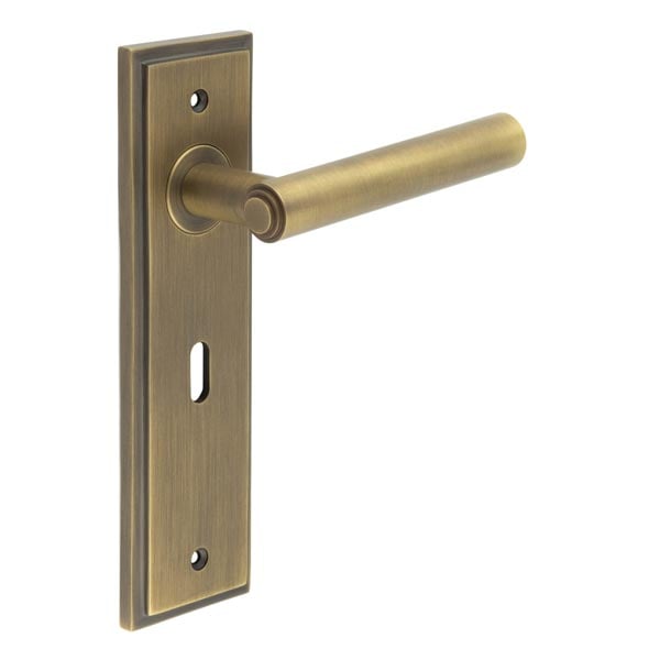 This is an image showing the Frelan - Richmond Door Handle Lock Backplate Antique Brass available to order from Trade Door Handles in Kendal