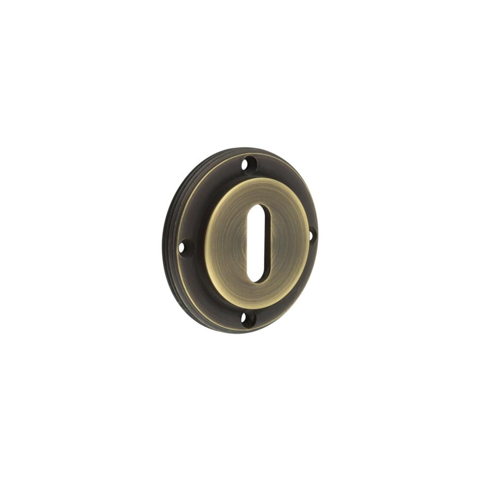 This is an image showing the Burlington - inner escutcheon std keyway - Antique Brass available to order from Trade Door Handles in Kendal