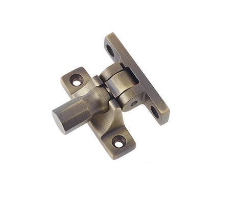 This is an image showing the Burlington - Brighton sash fastener - Antique Brass available to order from Trade Door Handles in Kendal