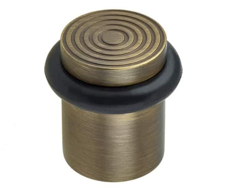 This is an image showing the Burlington - Floor mounted Door Stop - Antique Brass available to order from Trade Door Handles in Kendal