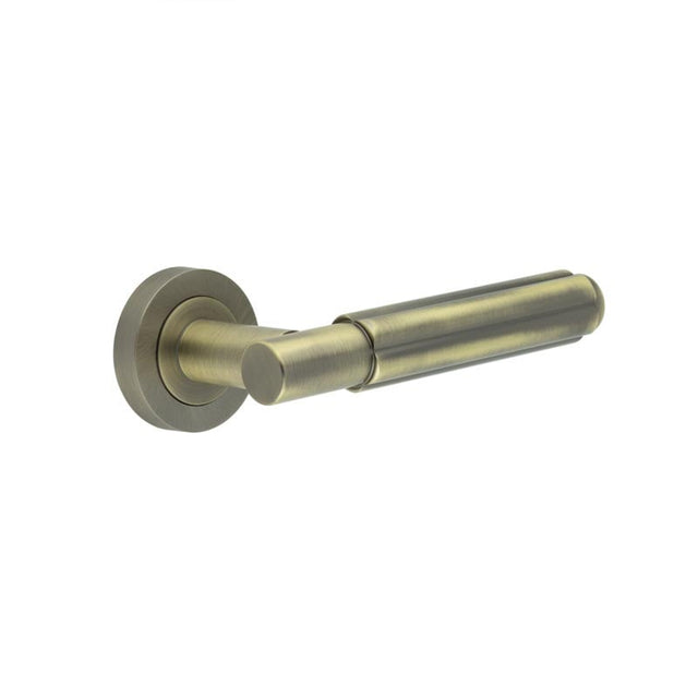 This is an image showing the Frelan - Bloom Antique Brass Lever on Rose available to order from Trade Door Handles in Kendal