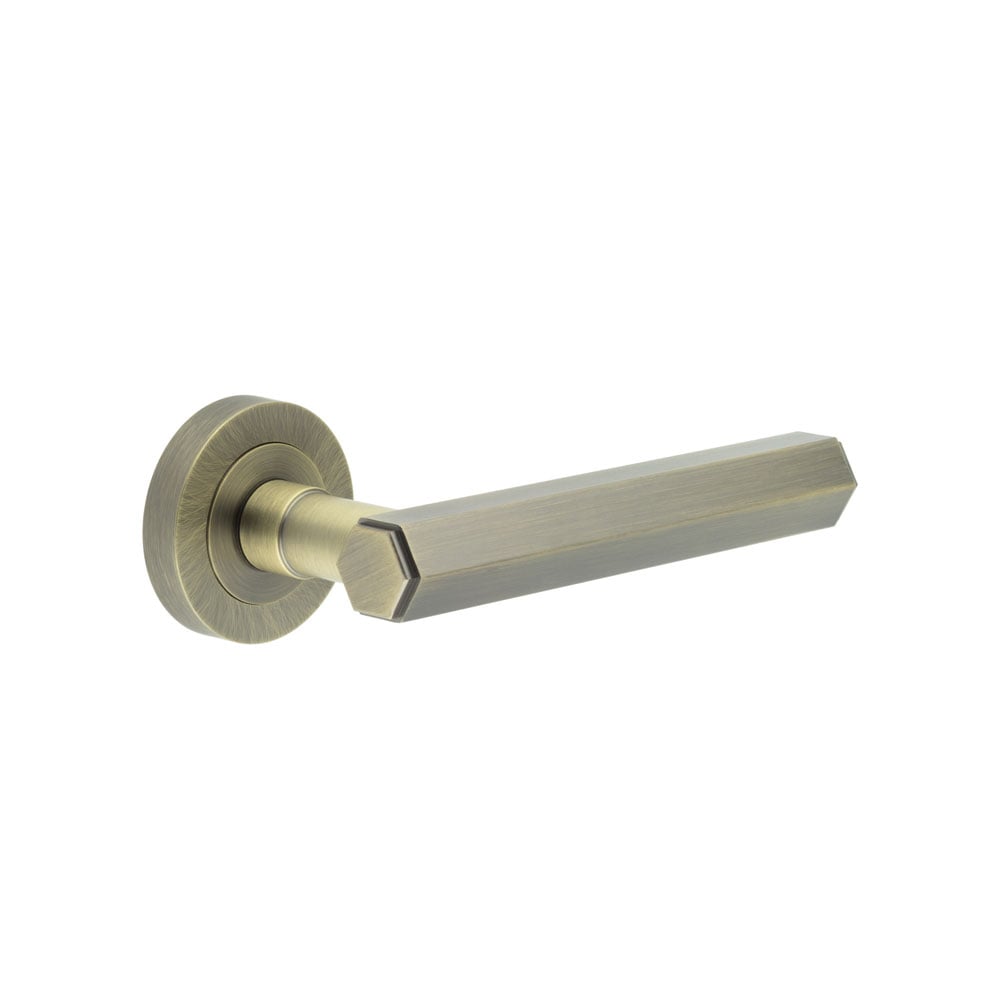 This is an image showing the Frelan - Jedo Hex Antique Brass Door Handle available to order from Trade Door Handles in Kendal