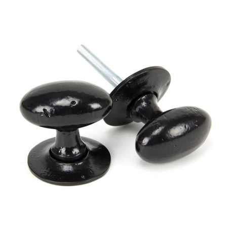 This is an image showing From The Anvil - Black Oval Mortice/Rim Knob Set available from trade door handles, quick delivery and discounted prices