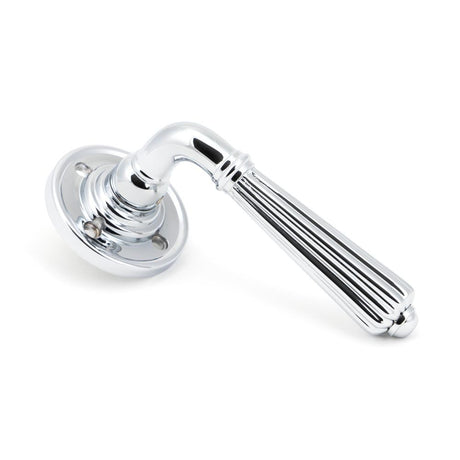 This is an image showing From The Anvil - Polished Chrome Hinton Lever on Rose Set available from trade door handles, quick delivery and discounted prices