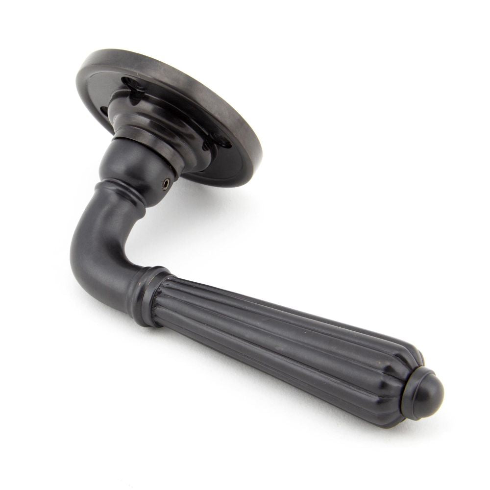 This is an image showing From The Anvil - Aged Bronze Hinton Lever on Rose Set available from trade door handles, quick delivery and discounted prices