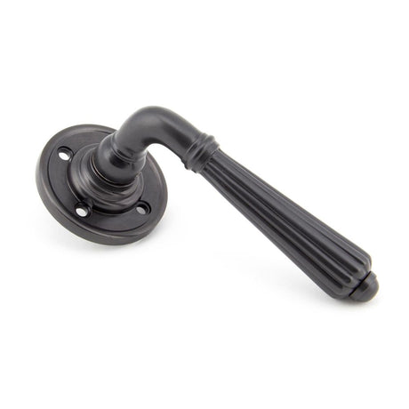 This is an image showing From The Anvil - Aged Bronze Hinton Lever on Rose Set available from trade door handles, quick delivery and discounted prices