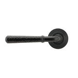 This is an image showing From The Anvil - Black Hammered Newbury Lever on Rose Set (Beehive) available from trade door handles, quick delivery and discounted prices