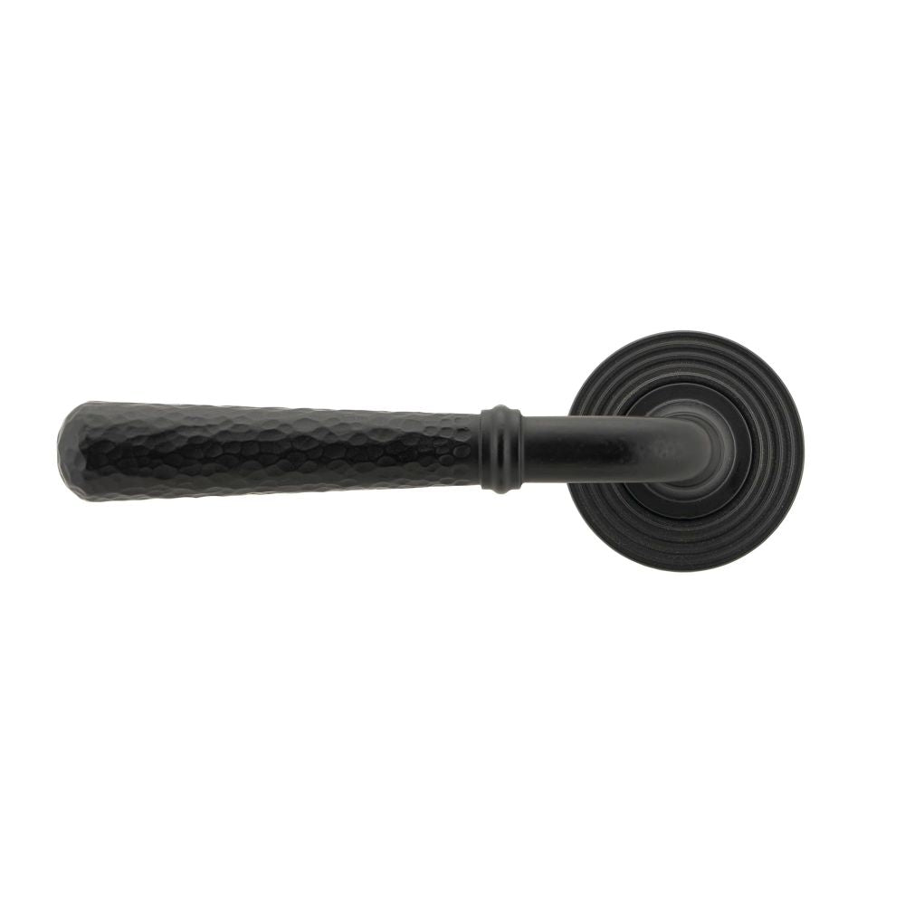 This is an image showing From The Anvil - Matt Black Hammered Newbury Lever on Rose Set (Beehive) available from trade door handles, quick delivery and discounted prices