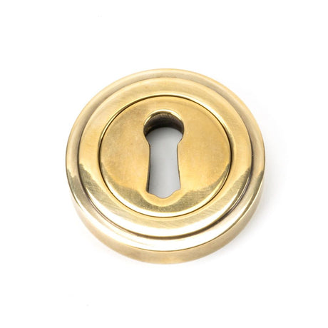 This is an image showing From The Anvil - Aged Brass Round Escutcheon (Art Deco) available from trade door handles, quick delivery and discounted prices