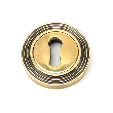This is an image showing From The Anvil - Aged Brass Round Escutcheon (Beehive) available from trade door handles, quick delivery and discounted prices