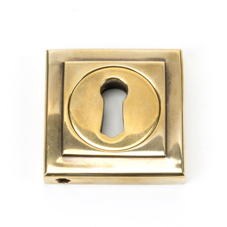 This is an image showing From The Anvil - Aged Brass Round Escutcheon (Square) available from trade door handles, quick delivery and discounted prices
