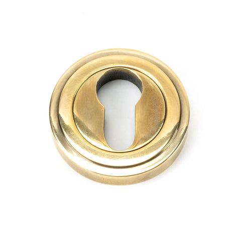 This is an image showing From The Anvil - Aged Brass Round Euro Escutcheon (Art Deco) available from trade door handles, quick delivery and discounted prices