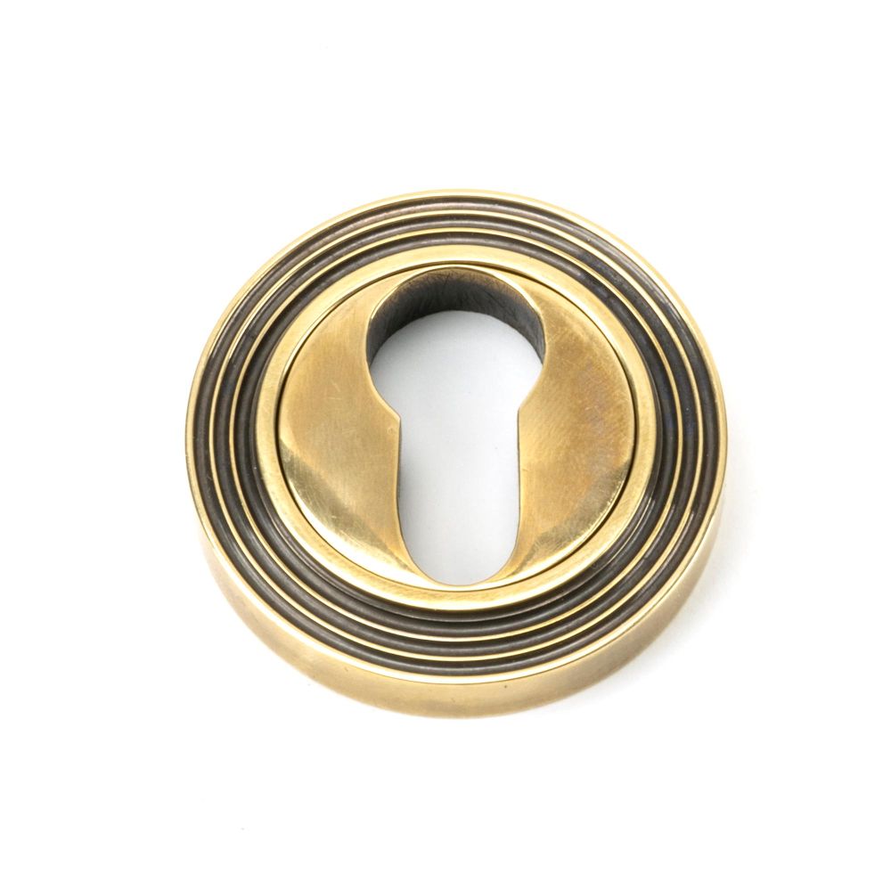 This is an image showing From The Anvil - Aged Brass Round Euro Escutcheon (Beehive) available from trade door handles, quick delivery and discounted prices