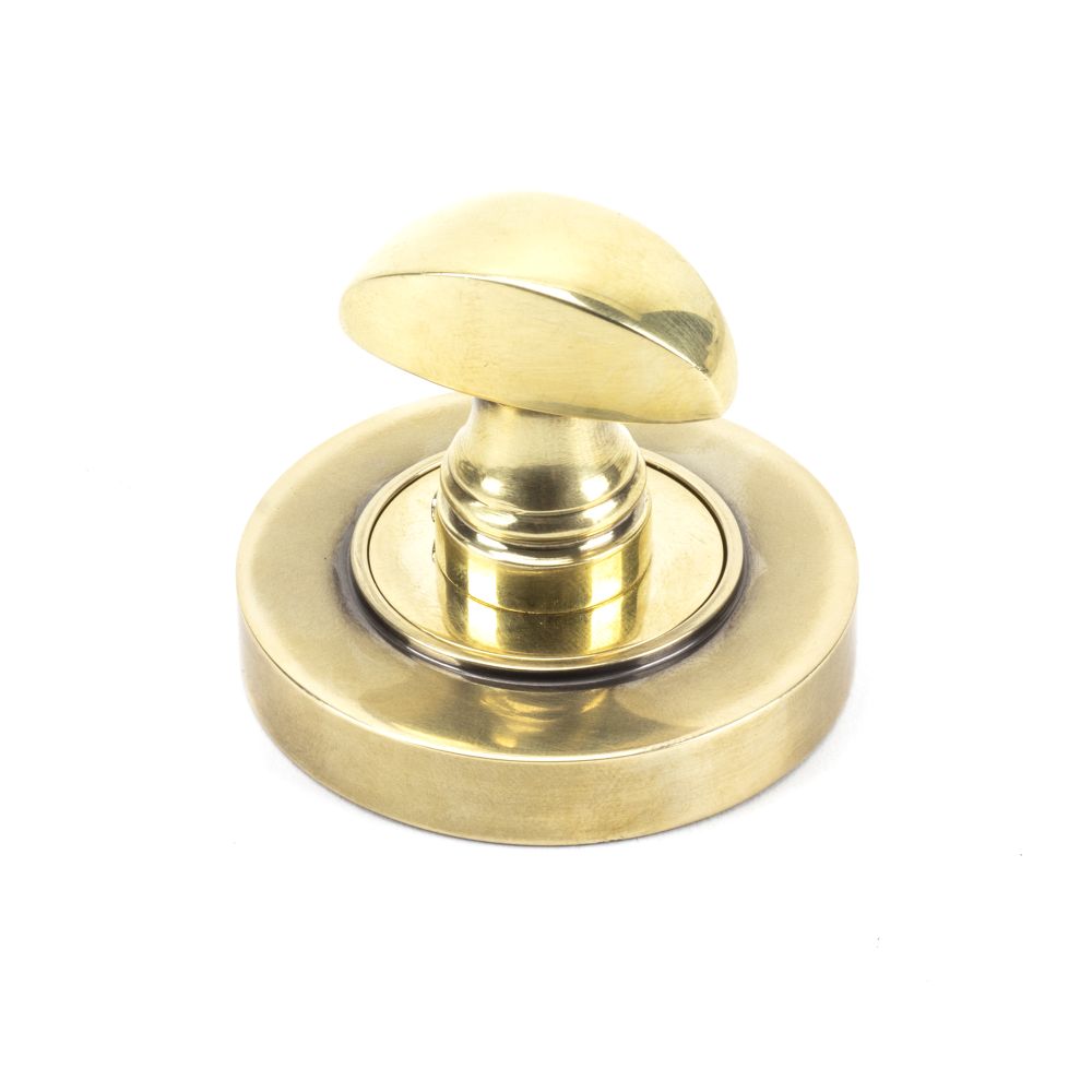 This is an image showing From The Anvil - Aged Brass Round Thumbturn Set (Plain) available from trade door handles, quick delivery and discounted prices