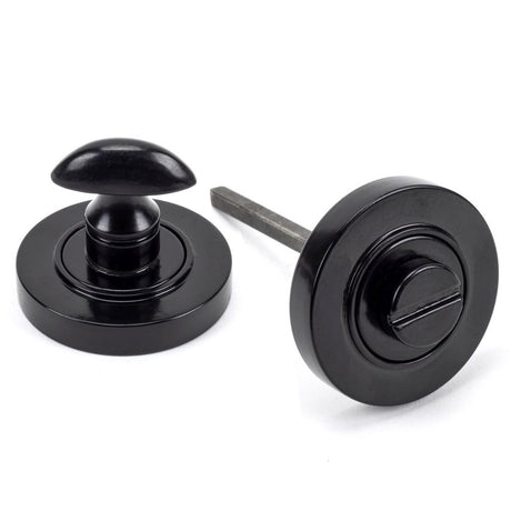 This is an image showing From The Anvil - Black Round Thumbturn Set (Plain) available from trade door handles, quick delivery and discounted prices