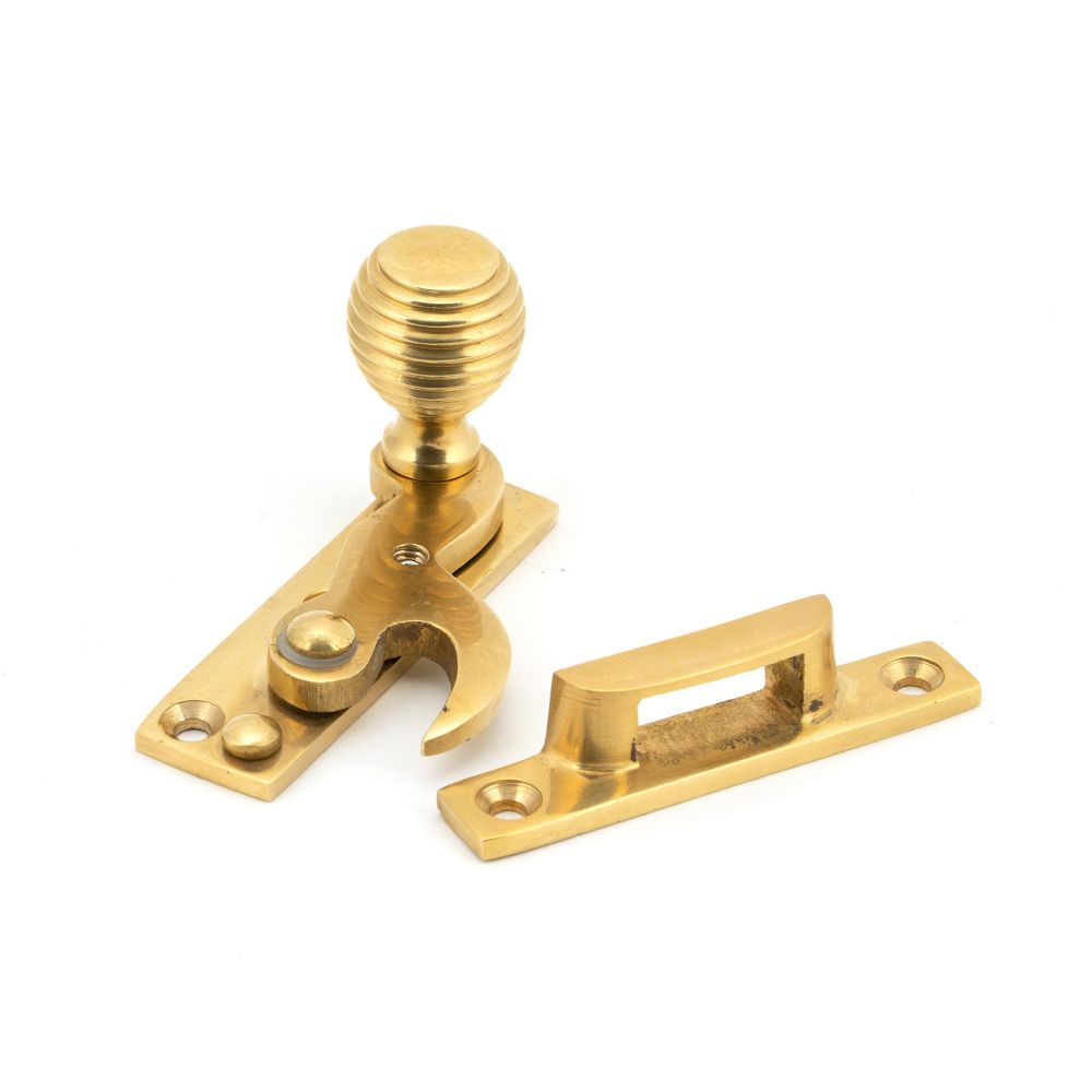 This is an image showing From The Anvil - Polished Brass Beehive Sash Hook Fastener available from trade door handles, quick delivery and discounted prices