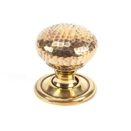 This is an image showing From The Anvil - Aged Brass Hammered Mushroom Cabinet Knob 32mm available from trade door handles, quick delivery and discounted prices
