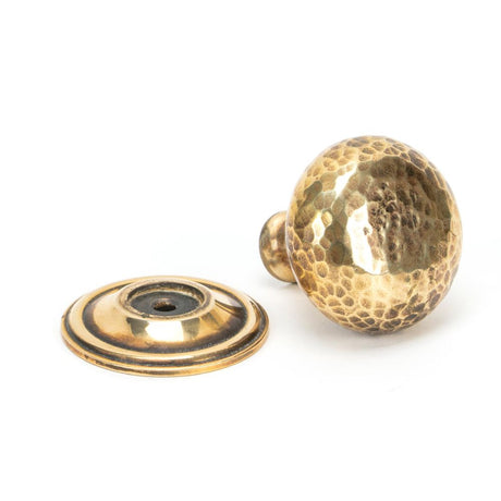 This is an image showing From The Anvil - Aged Brass Hammered Mushroom Cabinet Knob 38mm available from trade door handles, quick delivery and discounted prices