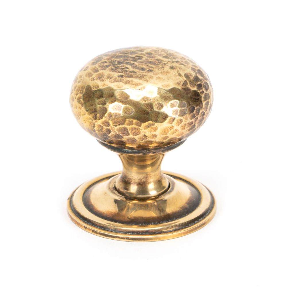 This is an image showing From The Anvil - Aged Brass Hammered Mushroom Cabinet Knob 38mm available from trade door handles, quick delivery and discounted prices