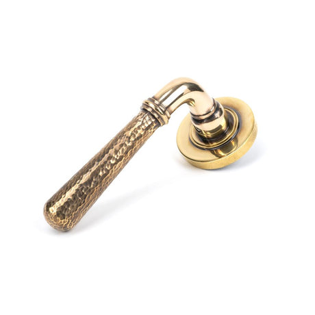 This is an image showing From The Anvil - Aged Brass Hammered Newbury Lever on Rose Set (Plain) available from trade door handles, quick delivery and discounted prices