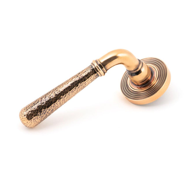 This is an image showing From The Anvil - Pol. Bronze Hammered Newbury Lever on Rose Set (Beehive) available from trade door handles, quick delivery and discounted prices