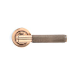 This is an image showing From The Anvil - Polished Bronze Brompton Lever on Rose Set (Plain) available from trade door handles, quick delivery and discounted prices