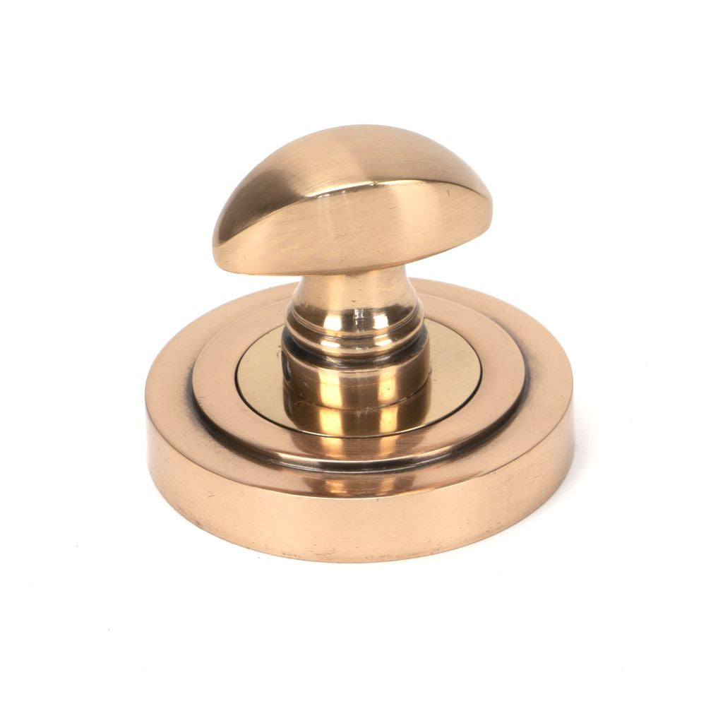 This is an image showing From The Anvil - Polished Bronze Round Thumbturn Set (Art Deco) available from trade door handles, quick delivery and discounted prices