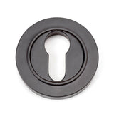 This is an image showing From The Anvil - Aged Bronze Round Euro Escutcheon (Plain) available from trade door handles, quick delivery and discounted prices