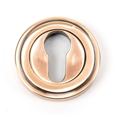 This is an image showing From The Anvil - Polished Bronze Round Euro Escutcheon (Art Deco) available from trade door handles, quick delivery and discounted prices